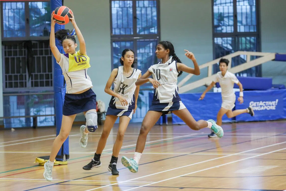 ST20240815_202489000406/rcnet15/Luther Lau/Rebekah Chia/ Action shots of Sarah Lim(In yellow from MGS), Zyra Helina Jocson, (middle) and Kaaviya D/O Kabil Dhew(Right from CHIJ) Participating in the Netball Finals C division. Taken at Jurong sports Hall.