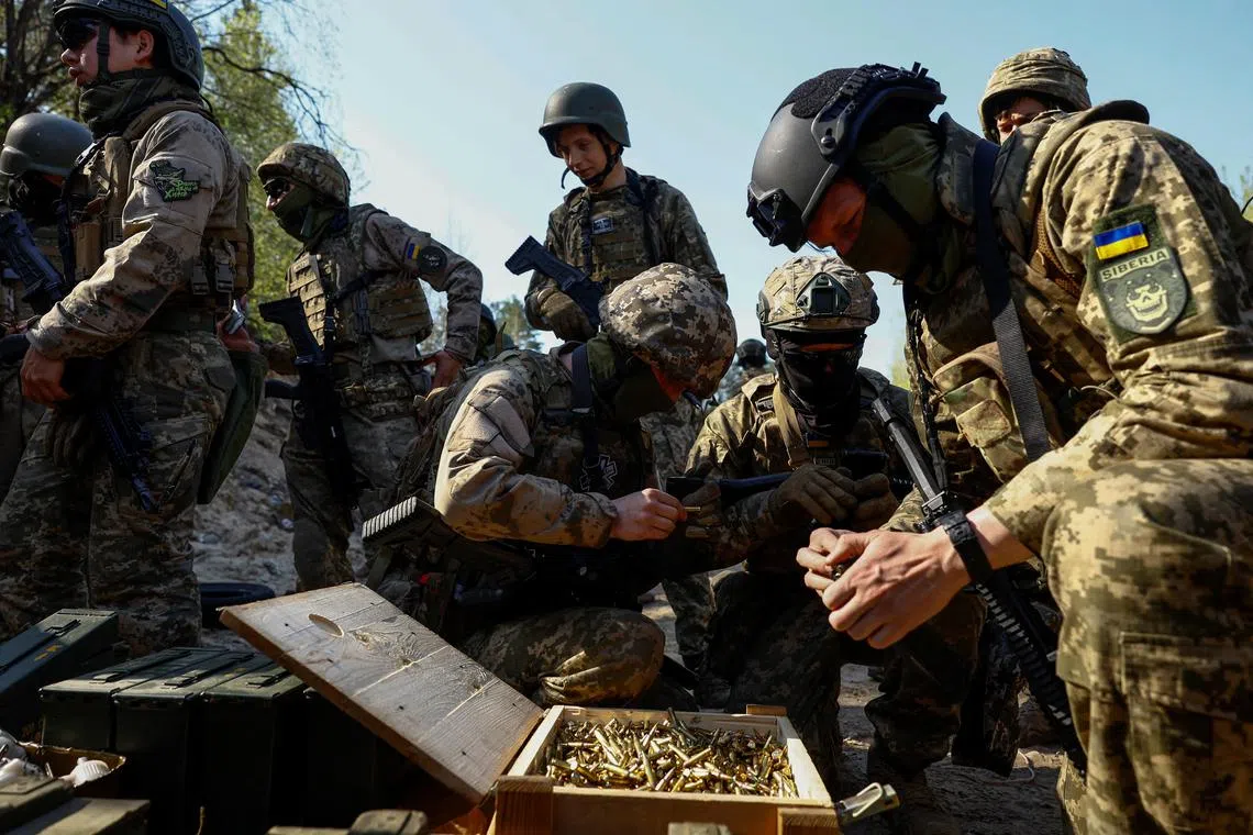 Ukrainian soldiers load ammunition into magazines during military exercises, at an undisclosed location in Ukraine's Kyiv region.