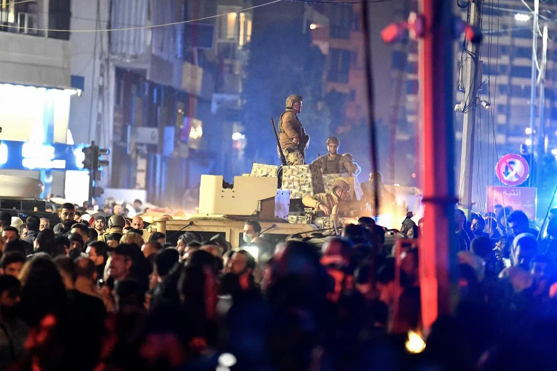epa11054044 Lebanese soldiers stand atop an armoured vehicle at the site of an explosion in the southern district of Dahiyeh, Beirut, Lebanon, 02 January 2024. According to Lebanese state media, at least six people were killed in an explosion following an Israeli drone strike, including Hamas deputy head, Saleh al-Arouri.  EPA-EFE/ABBAS SALMAN