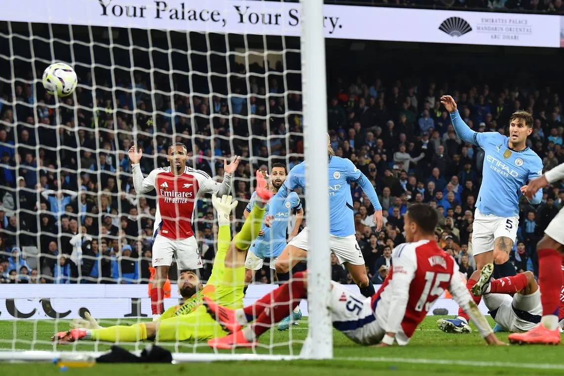 Manchester City's John Stones (right) scores the 2-2 goal during the match between Manchester City and Arsenal in Manchester.
