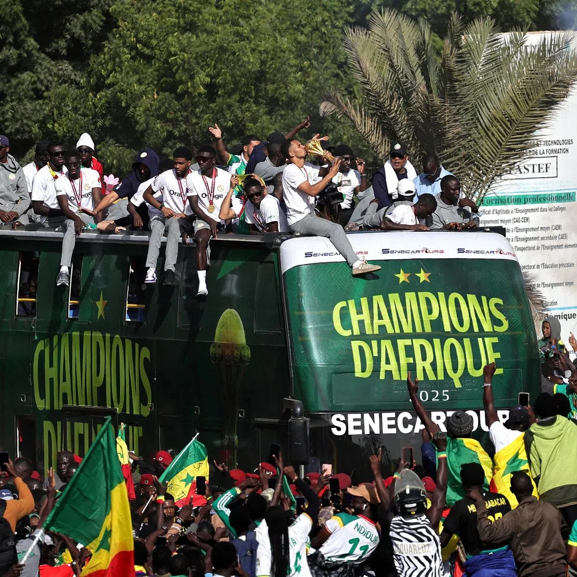Soccer Football - CAF Africa Cup of Nations - Morocco 2025 - Final - Senegal Victory Parade - Dakar, Senegal - January 20, 2026 Senegal players and staff celebrate with the trophy on the bus during the victory parade. REUTERS/Zohra Bensemra