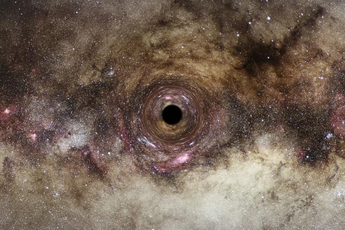 An artist’s impression of a black hole, which distorts light passing near it creating a phenomenon known as “gravitational lensing”.