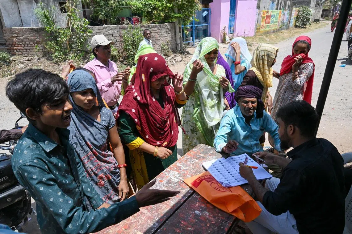 Voters register at a polling station during the third phase of voting for national elections in Ahmedabad, Gujarat, India, on May 7.