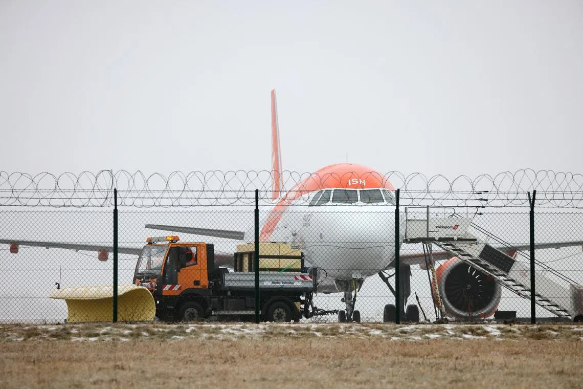 An easyJet plane, as a de-icing vehicle works at Berlin Brandenburg Airport, which was closed due to severe ice on taxiways caused by freezing rain, in Berlin, Germany, February 6, 2026. REUTERS/Liesa Johannssen