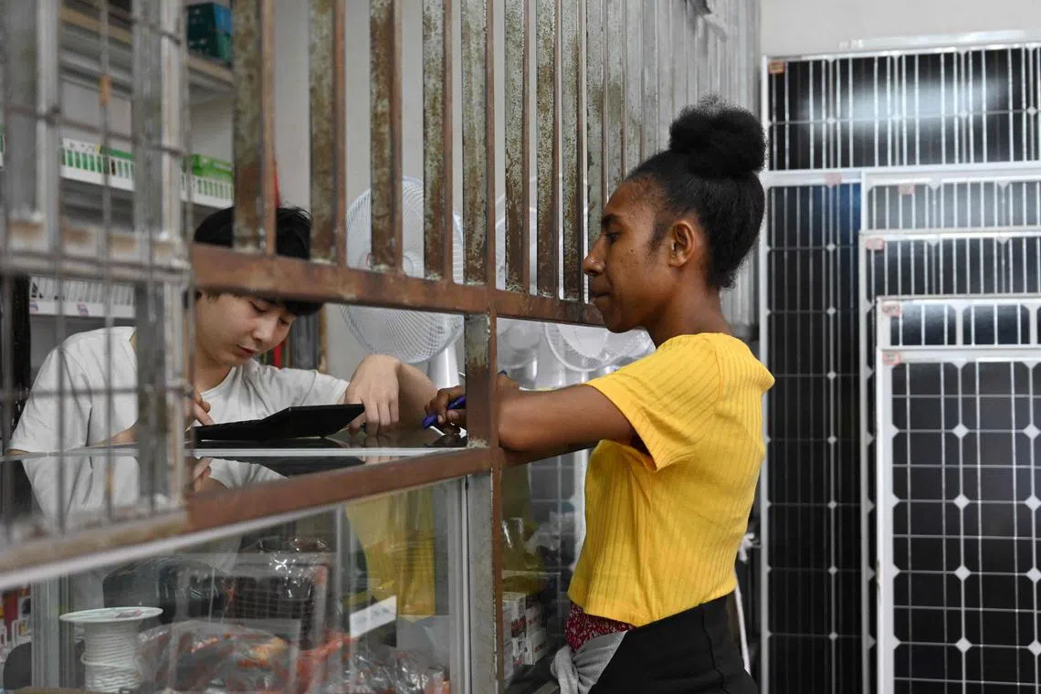 A Chinese cashier working at a Chinese store in Port Moresby, Papua New Guinea.