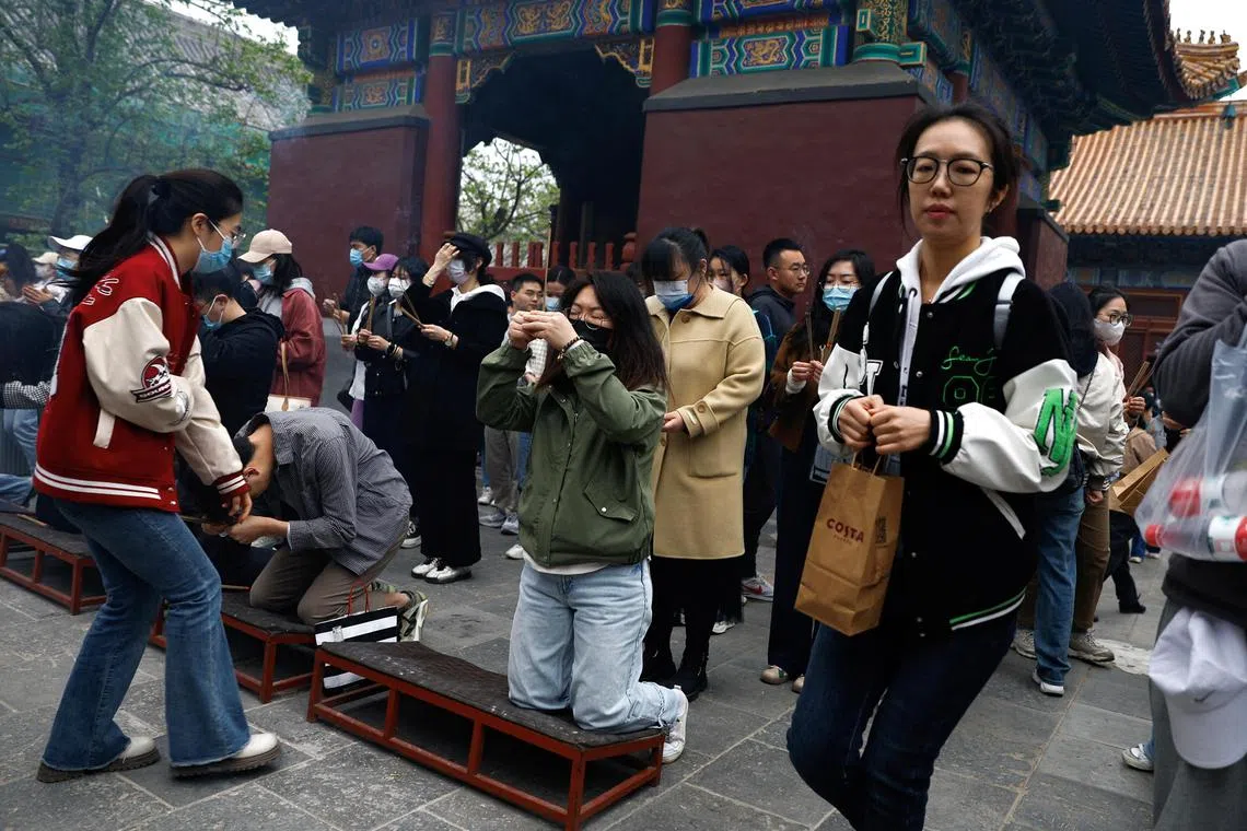 People burn incense sticks to pray for good fortune at Lama Temple, in Beijing.