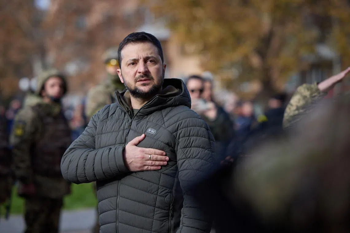 Ukrainian President Volodymyr Zelensky takes part in a flag-raising ceremony in the newly liberated city of Kherson, on Nov 14, 2022.
