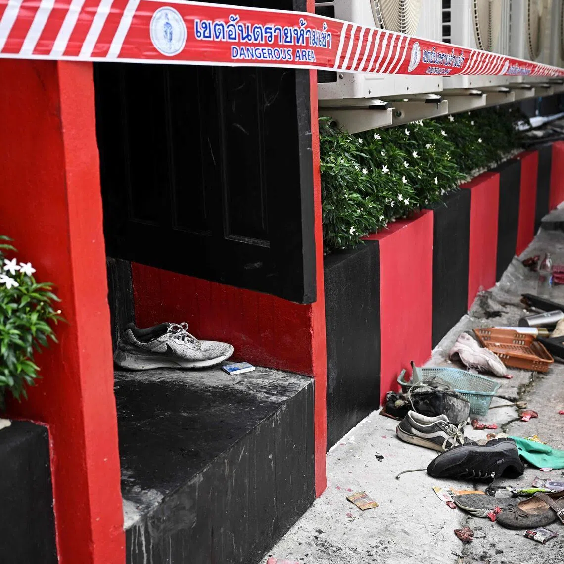 Shoes are seen at the back door in the aftermath of a fire at the Rong Beer Na Lat Phrao bar in Bangkok on July 13.