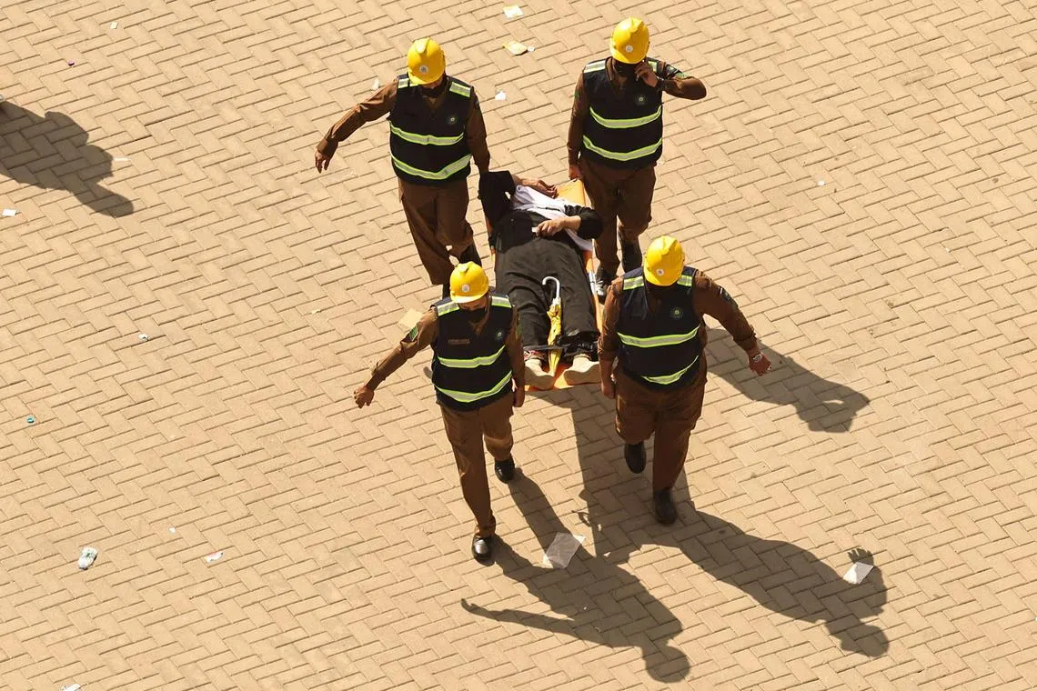 Rescuers carry away a man, affected by the scorching heat on a stretcher in Mina, Saudi Arabia, on June 16, 2024. 
