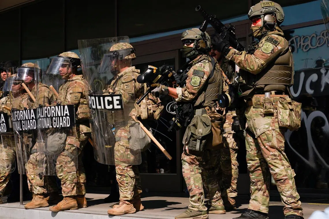 FILE PHOTO: California National Guard troops stand guard as people attend a rally against federal immigration sweeps, in Los Angeles, California, U.S. June 9, 2025. REUTERS/David Ryder/File Photo