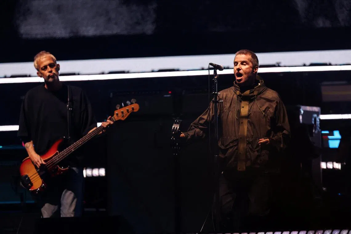Liam Gallagher and Gem Archer of Oasis perform during the first of their sellout comeback shows at the Cardiff Principality Stadium.
