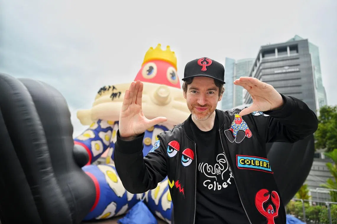 British artist Philip Colbert raises his hands to create lobster claws 