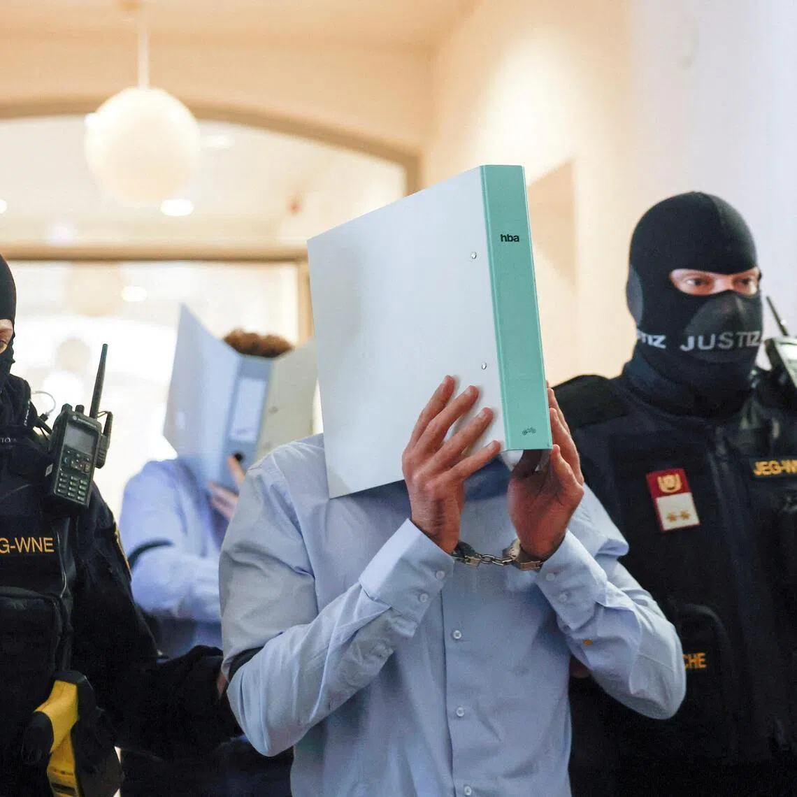 The Austrian defendant identified as Beran A is escorted by security personnel in a courtroom for his trial in Wiener Neustadt, Austria, on May 28.