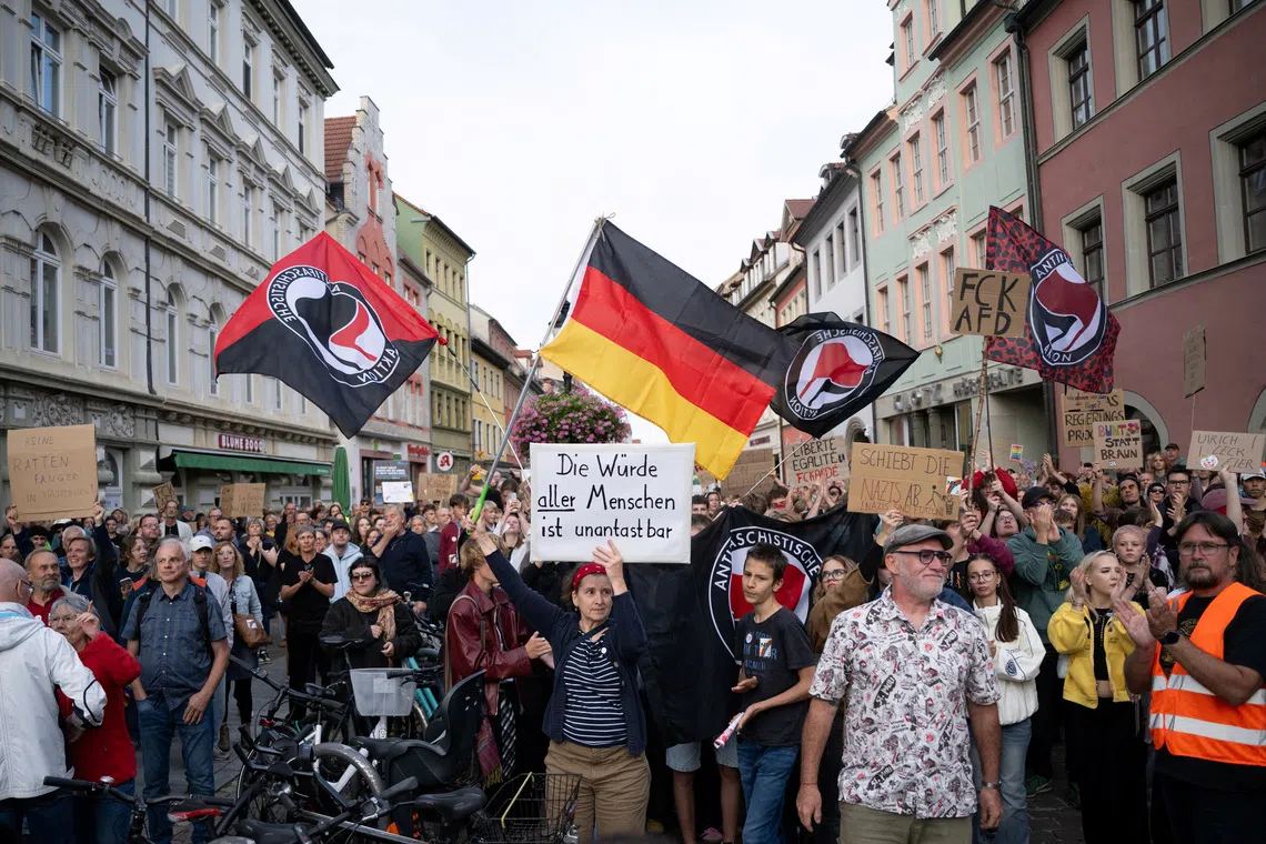 People hold posters during a counter-protest at a campaign rally of the far-right Alternative for Germany (AfD) in Naumburg, a former Soviet garrison town, in Saxony-Anhalt, Germany, ahead of the state election on September 6, where the party hopes to secure enough votes to lead a state government for the first time in Germany, August 24, 2026. REUTERS/Annegret Hilse