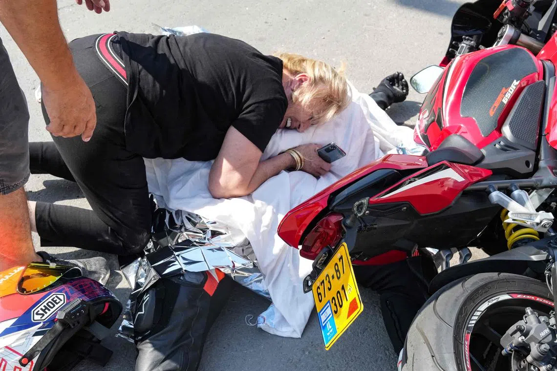 A woman weeps over the covered body of her nephew, who was shot dead in the southern Israeli city of Sderot.