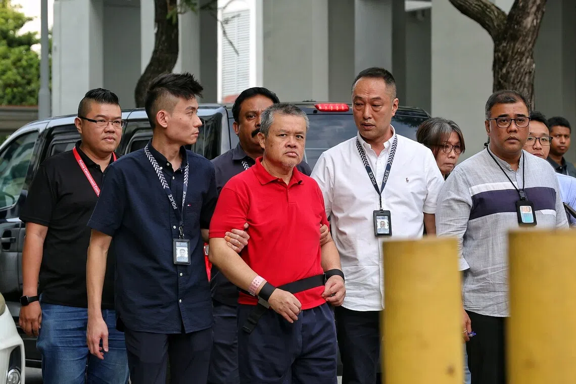 A handcuffed Ng Swee Seng, wearing a red polo T-shirt and shorts, arrived at 9.20am with restraints around his feet, in a black van flanked by several officers.
