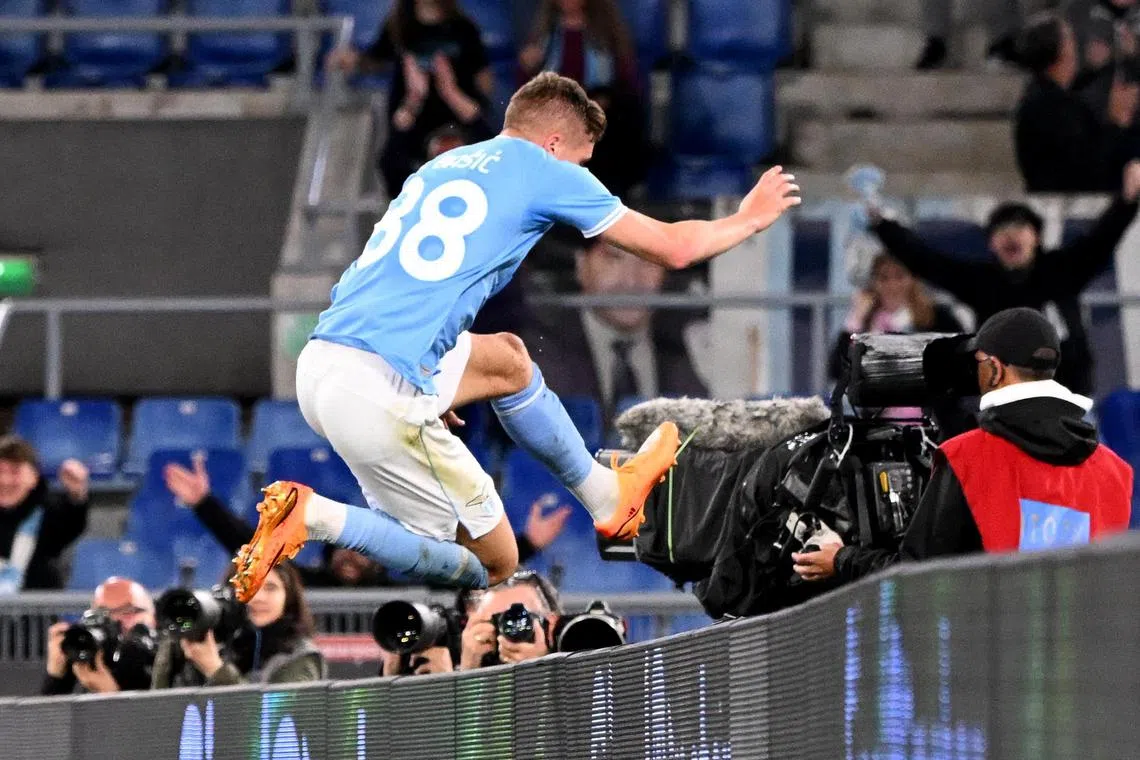 Lazio's Toma Basic, in a number 88 shirt, celebrates scoring a goal.