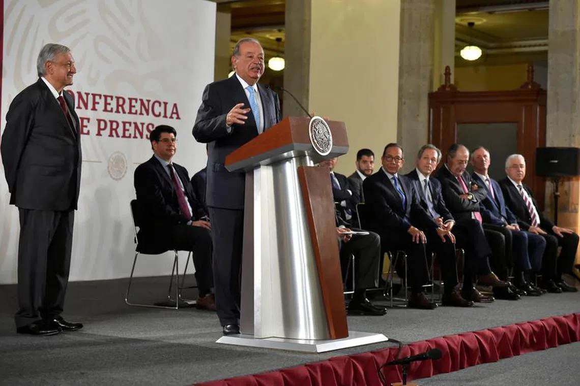 FILE PHOTO: Mexican tycoon Carlos Slim speaks as Mexico's President Andres Manuel Lopez Obrador (L) looks on at the National Palace in Mexico City, Mexico August 27, 2019. Press Office Andres Manuel Lopez Obrador/Handout via REUTERS/File Photo