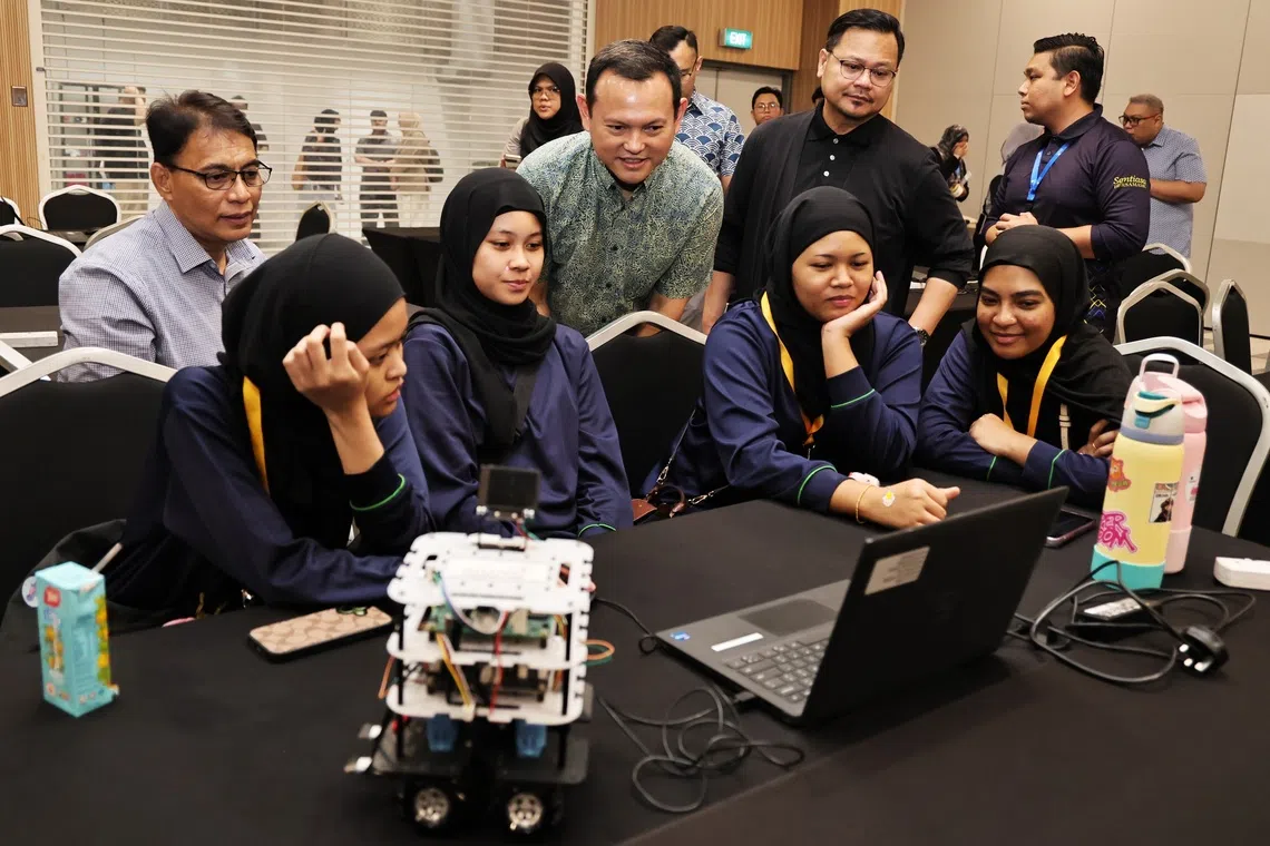 Acting Minister-in-charge of Muslim Affairs Zaqy Mohamad interacting with participants at a programming workshop at the Singapore University of Technology and Design on Aug 29.