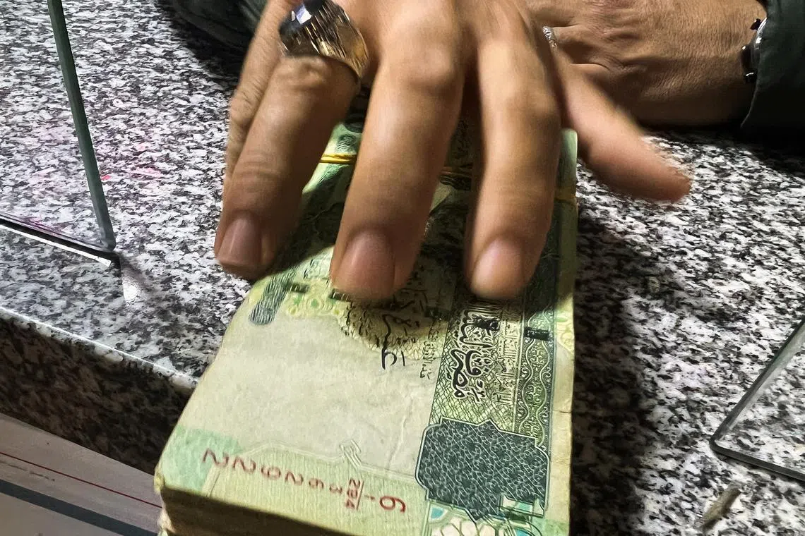A man receives money from a bank employee in Misrata, Libya, April 9, 2024. REUTERS/Ayman al-Sahili/File Photo