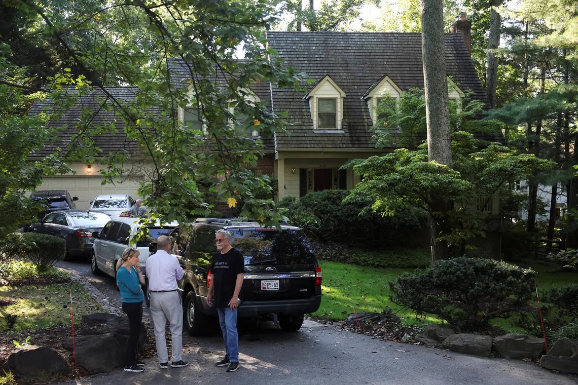 People stand outside the home of the former White House national security adviser John Bolton as it is searched by the U.S. law enforcement agency in Bethesda, Maryland, U.S., August 22, 2025. REUTERS/Tasos Katopodis