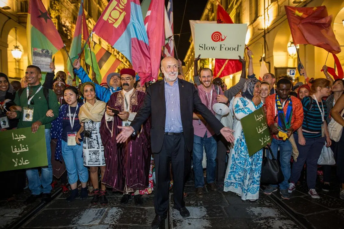 Carlo Petrini, founder of the Italian ‘Slow Food’ movement that promotes quality food, genuine ingredients and local produce, walks with participants during a Slow Food gathering in this undated handout picture. SLOW FOOD/Handout via REUTERS