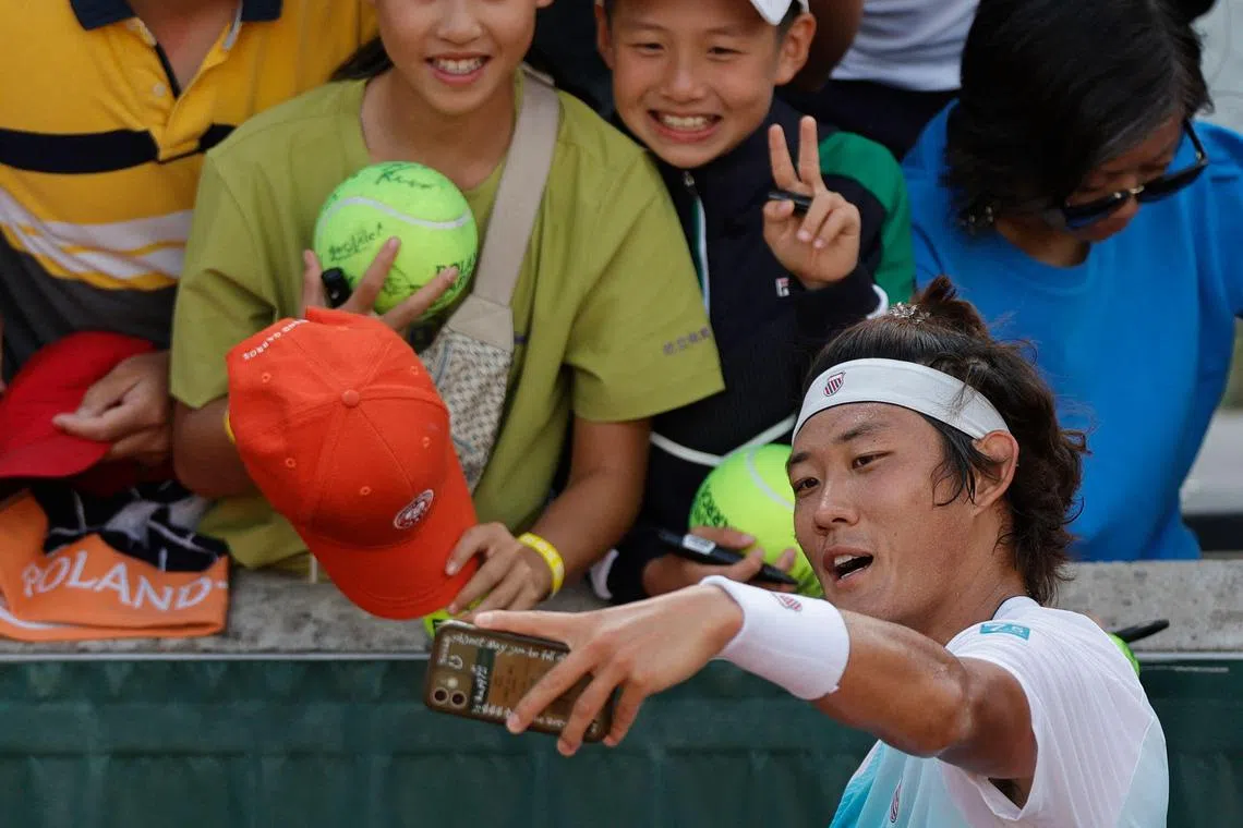 China's Zhang Zhizhen poses for a wefie with fans after his victory over Serbia's Dusan Lajovic.