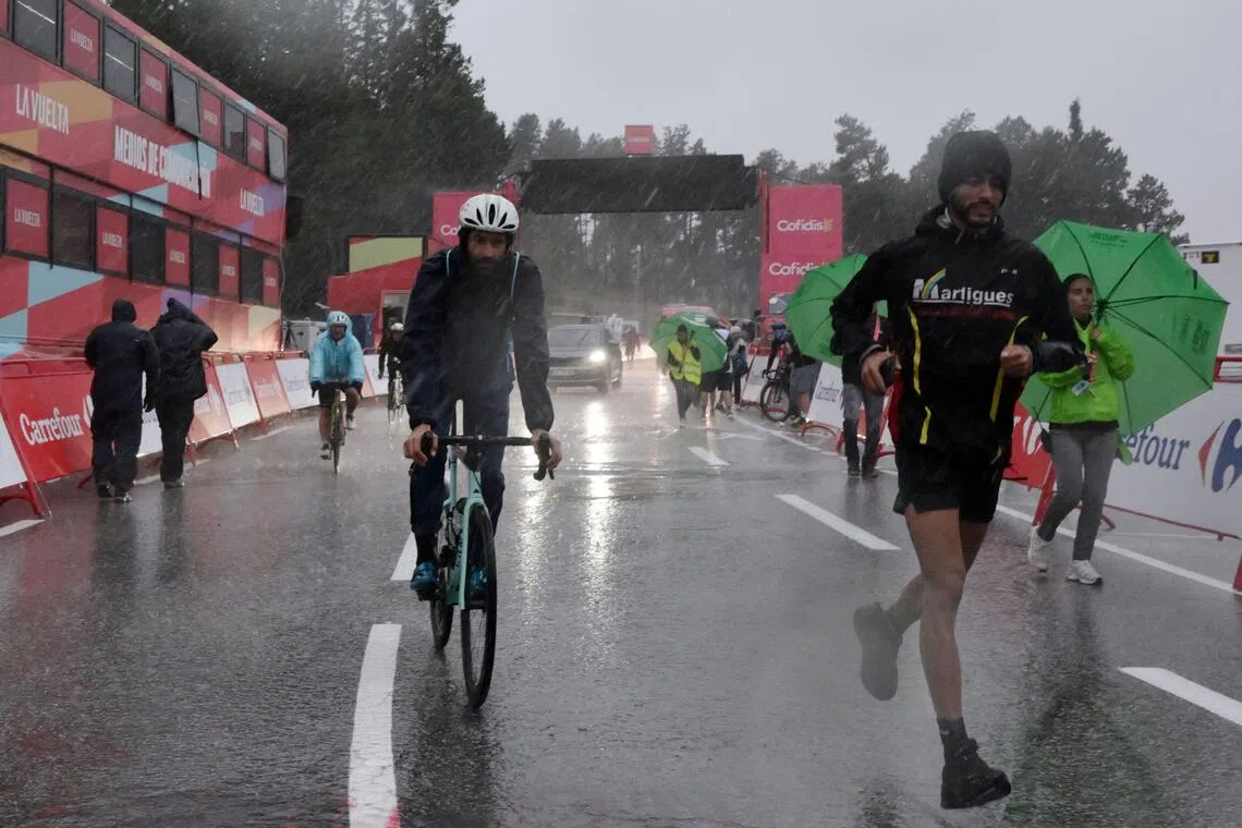 People leaving after a heavy hailstorm hit the finish area of the third stage of the Vuelta a Espana 2026 on Aug 24. The stage was abandoned inside the final few kilometres.