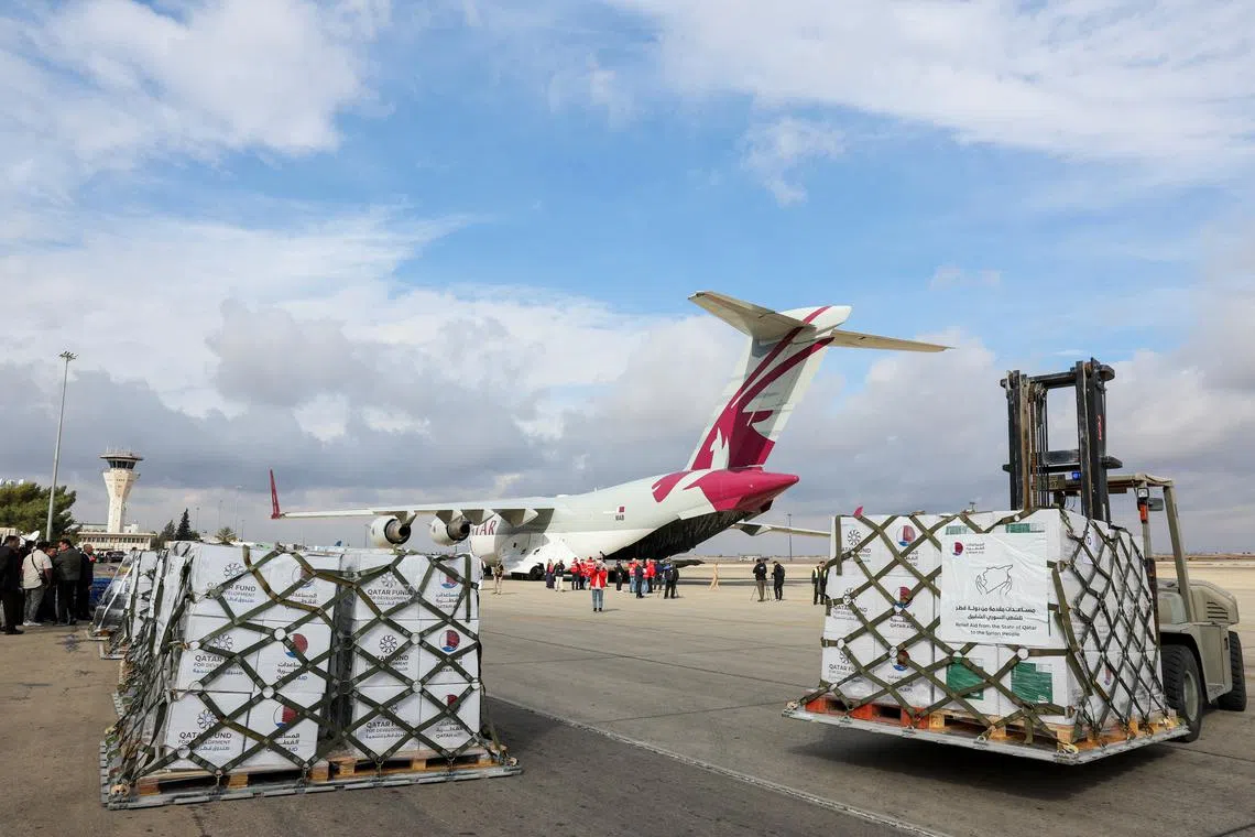 FILE PHOTO: People stand near a plane carrying aid from Qatar, as it arrives at Damascus International Airport, Syria, December 30, 2024. REUTERS/Yamam al Shaar/File Photo