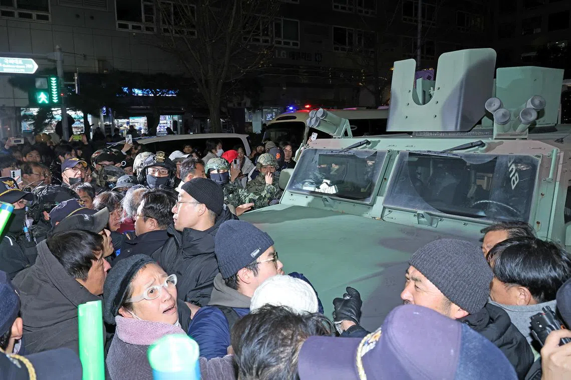 People surrounding a military vehicle outside the National Assembly in Seoul after South Korean President Yoon Suk Yeol declared martial law in Seoul, Dec 4, 2024. South Korean President Yoon Suk Yeol had declared martial law on the night of Dec 3, citing the need to root out pro-North Korean forces and uphold the constitutional order. 