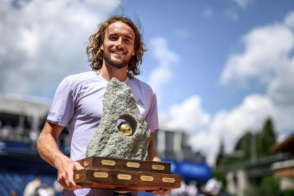 Greece's Stefanos Tsitsipas poses with the trophy following his victory against Belgium's Raphael Collignon during their men's singles final match at the Swiss Open tennis tournament in Gstaad, on July 19, 2026. (Photo by Fabrice COFFRINI / AFP)