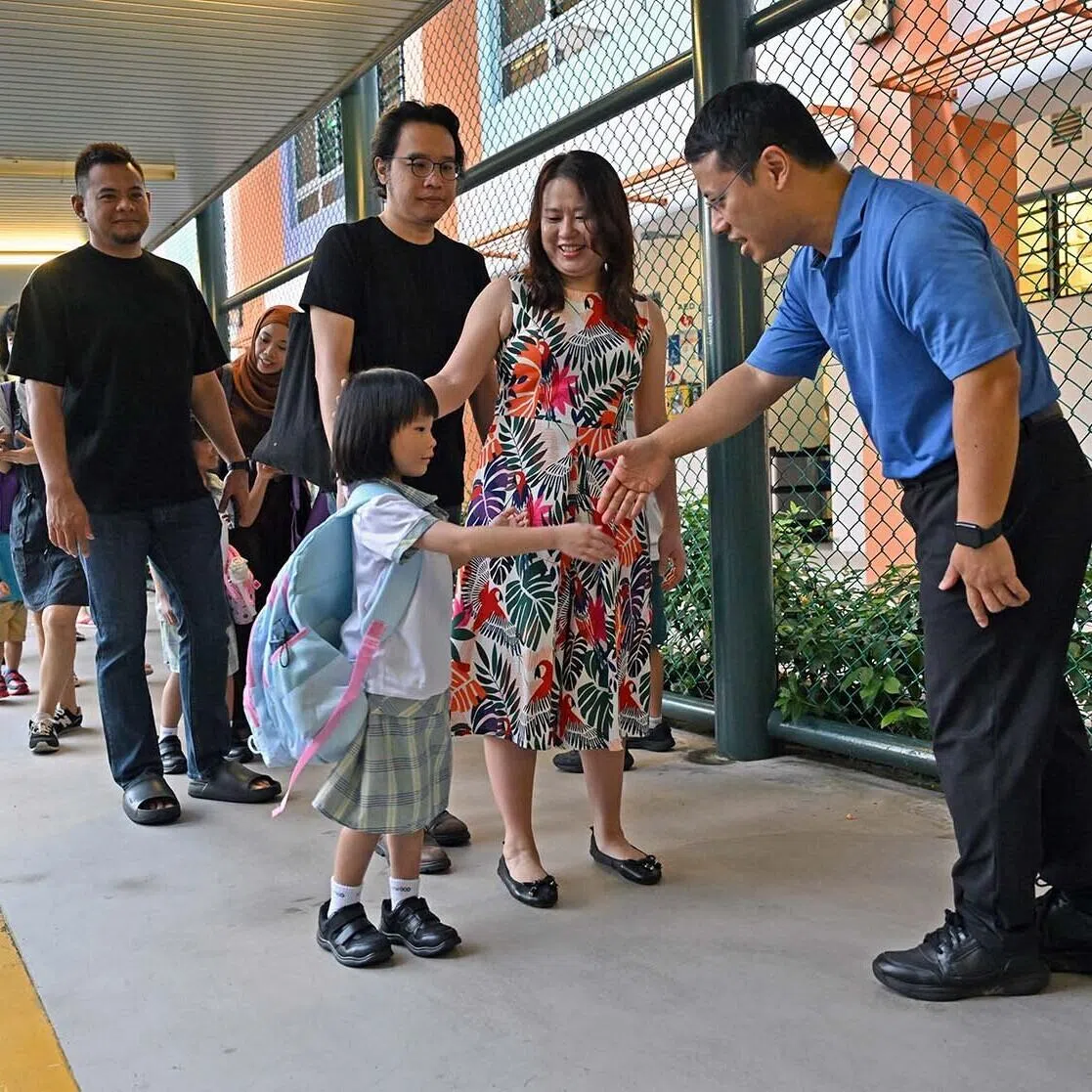 Minister for Education, Mr Desmond Lee (right), greeting Elliana Liow on her first day of school at Westwood Primary School Jan 2, 2026. 