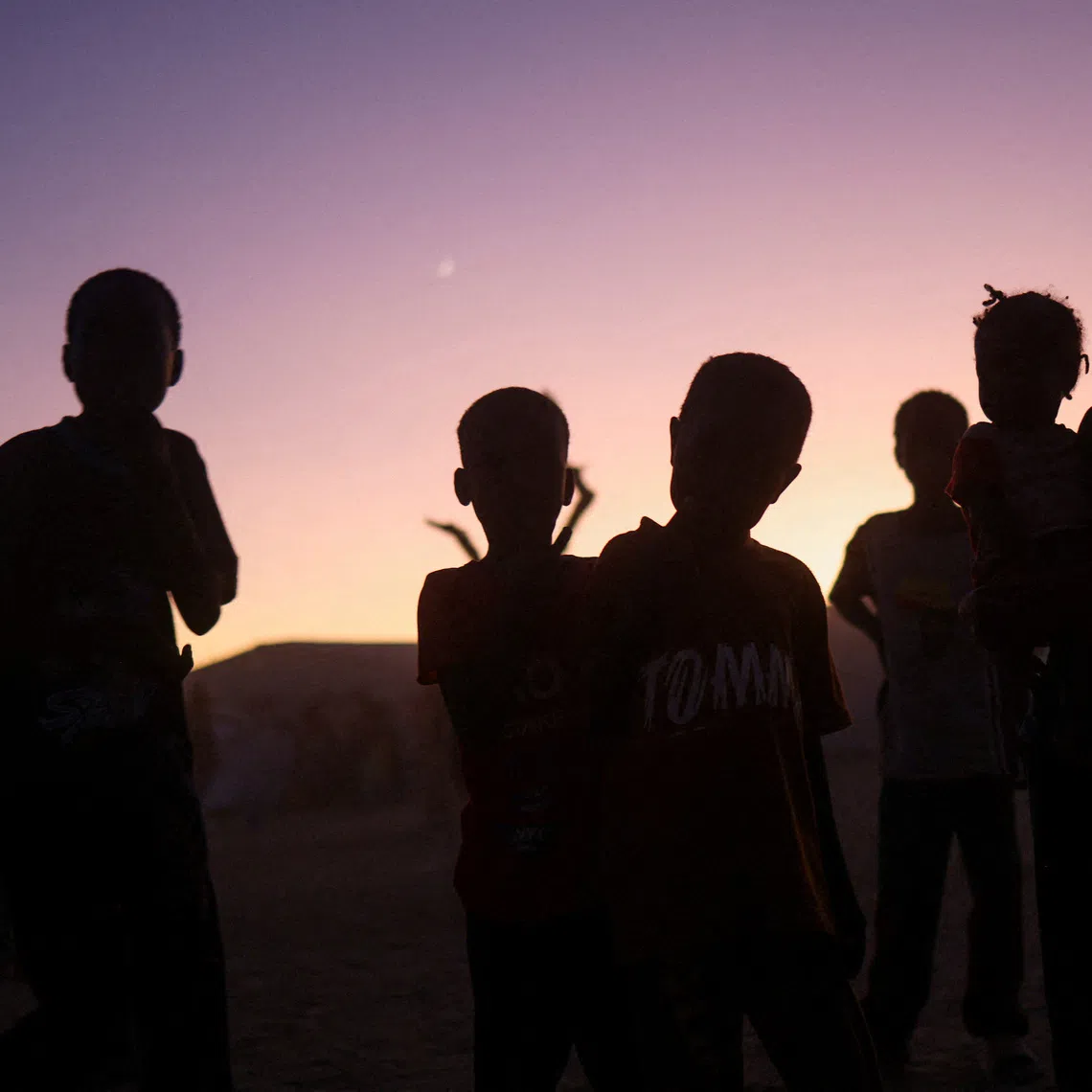 FILE PHOTO: Sudanese refugee children from al-Fashir stand at sunset in the Tine transit camp amid the conflict between the paramilitary Rapid Support Forces (RSF) and the Sudanese Army, in eastern Chad, November 23, 2025. REUTERS/Amr Abdallah Dalsh/File Photo