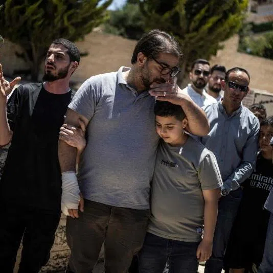 Palestinian father Fahd Abou Haikal comforts his elder son Kinan after burying his seven-month-old baby Sam Fahd Abou Haikal, on June 6, 2026, in Hebron, in the occupied West Bank.