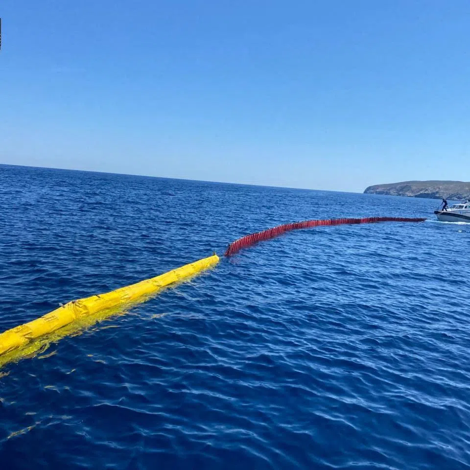 Hellenic Coast Guard members take part in an operation to prevent sea pollution, after a cargo ship ran aground and sank off the island of Andros, Greece, May 6, 2026. Hellenic Coast Guard/Handout via REUTERS