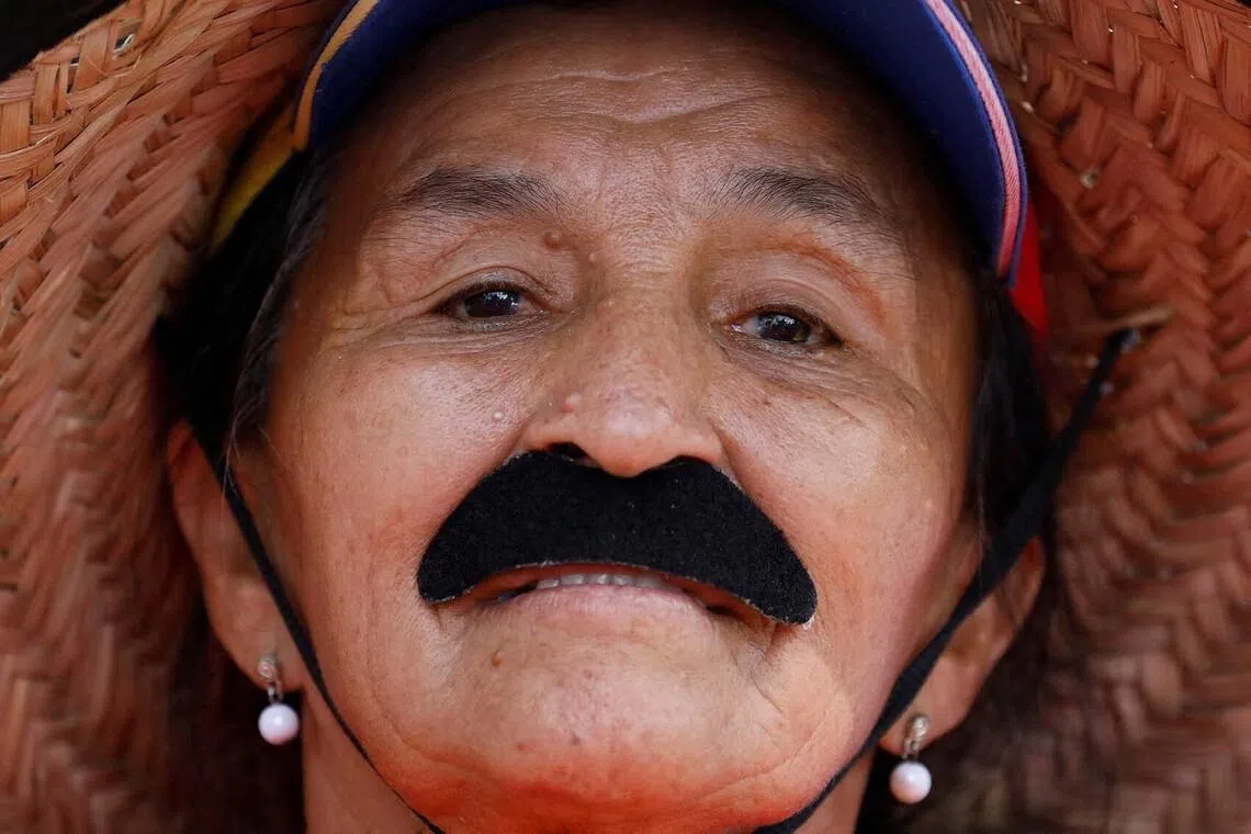 A woman wears a fake mustache during a women's march toward the office of interim President Delcy Rodriguez, days after the U.S. launched a strike on Venezuela and captured President Nicolas Maduro and his wife Cilia Flores, in Caracas, Venezuela, January 6, 2026. REUTERS/Leonardo Fernandez Viloria TPX IMAGES OF THE DAY