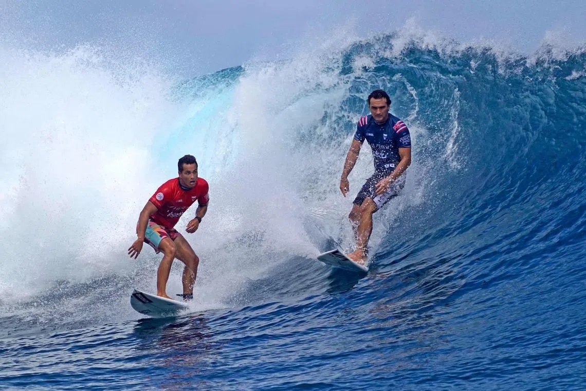 Brazil's Gabriel Medina (left) and USA's John John Florence ride a wave during the World Surf League (WSL) Tahiti pro competition, also a surfing test event for the Paris Olympic Games 2024, in Teahupo'o in Tahiti.