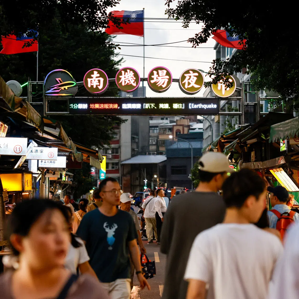 People walk through Nanjichang Night Market beneath Taiwan flags in Taipei, Taiwan, September 24, 2026. REUTERS/Ann Wang
