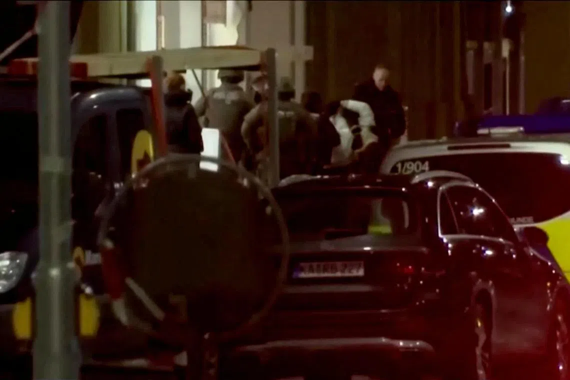Police bring a detained person out of the pharmacy in Karlsruhe, Germany.