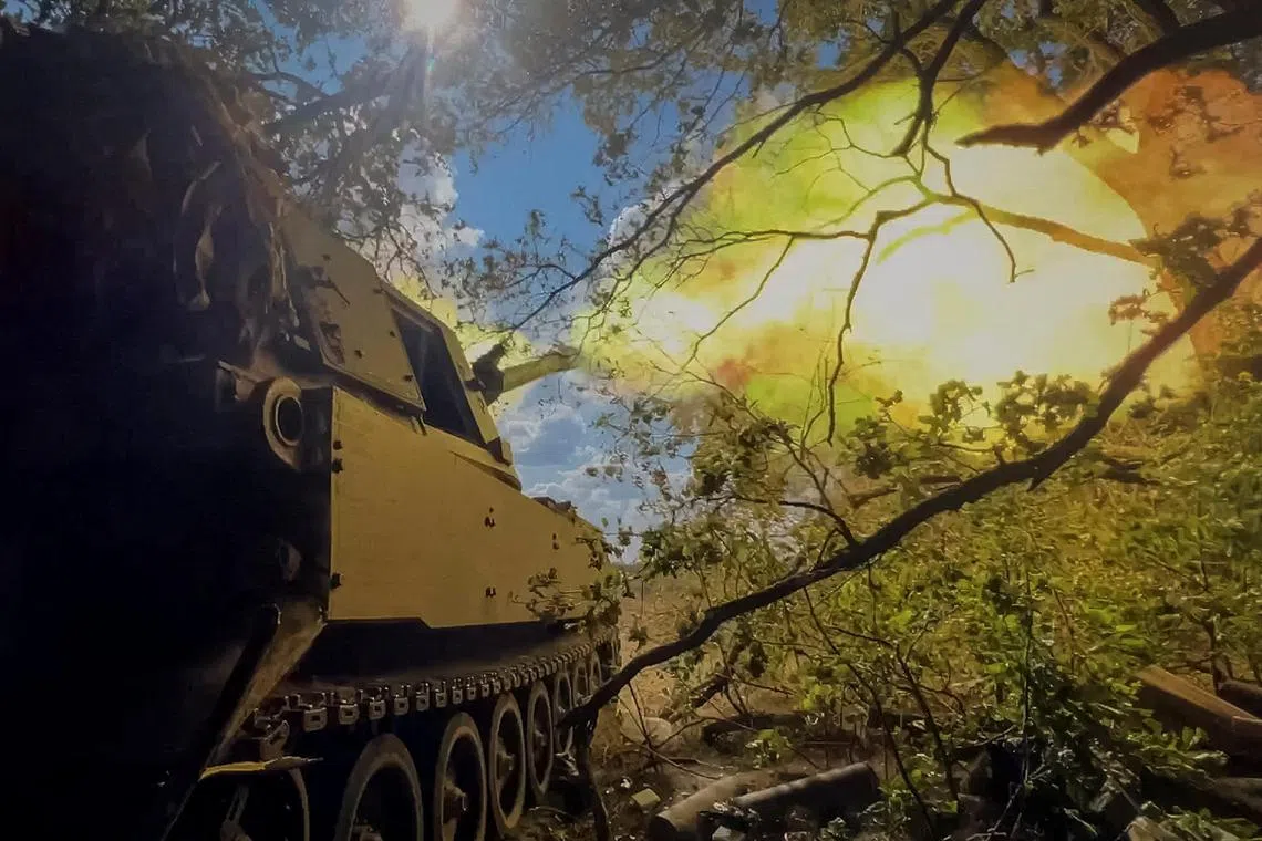 Ukrainian servicemen fire a self-propelled howitzer towards Russian troops, in Ukraine's Donetsk region.