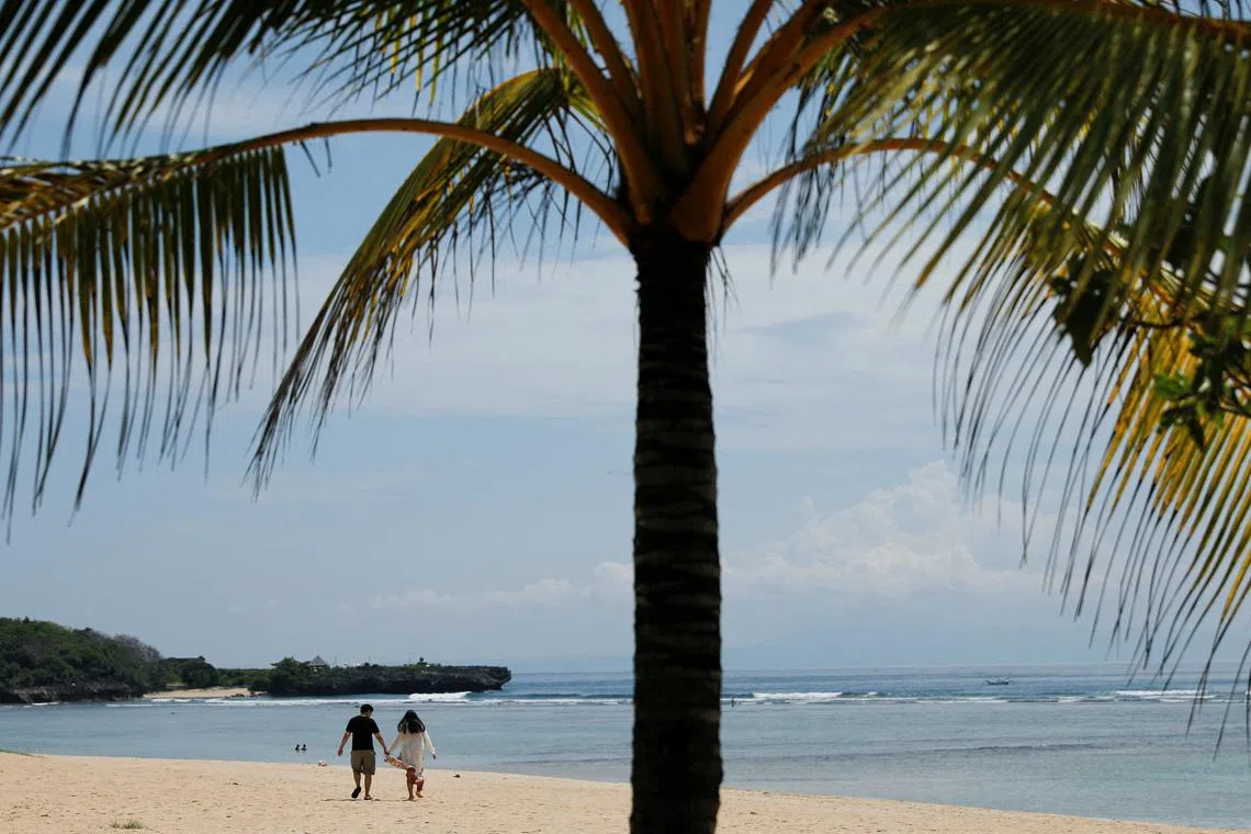 FILE PHOTO: A couple walk along the beach in Nusa Dua, Bali, Indonesia, November 17, 2022.REUTERS/Willy Kurniawan/File Photo