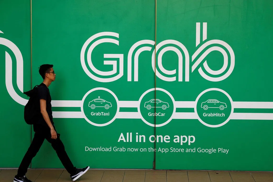 FILE PHOTO: A man walks past a Grab office in Singapore March 26, 2018. REUTERS/Edgar Su/File Photo