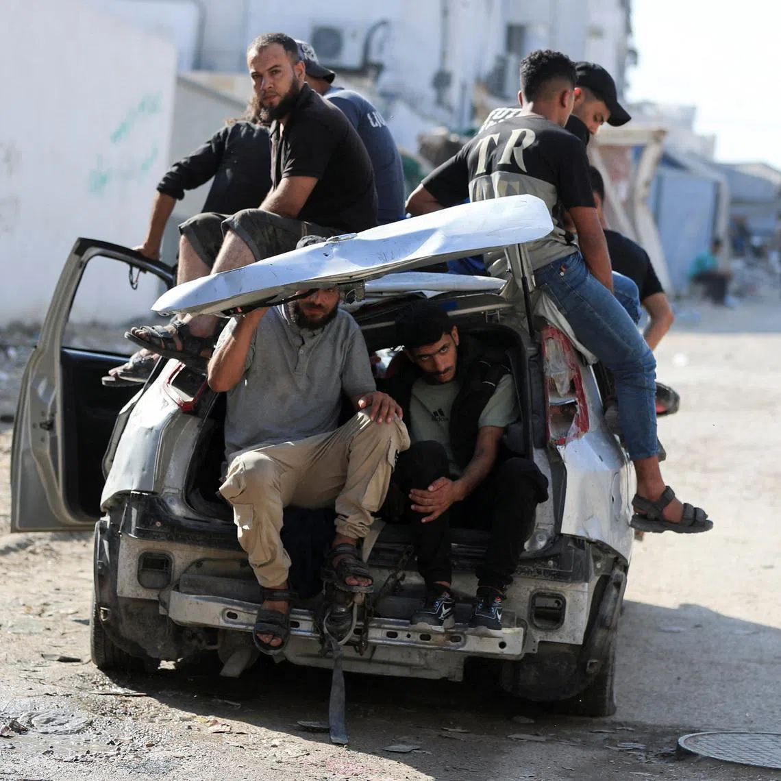 Mourners sit inside and atop a damaged car during the funeral of three Palestinians, who were killed in an Israeli strike, according to medics, in Gaza City, July 16, 2026. REUTERS/Dawoud Abu Alkas