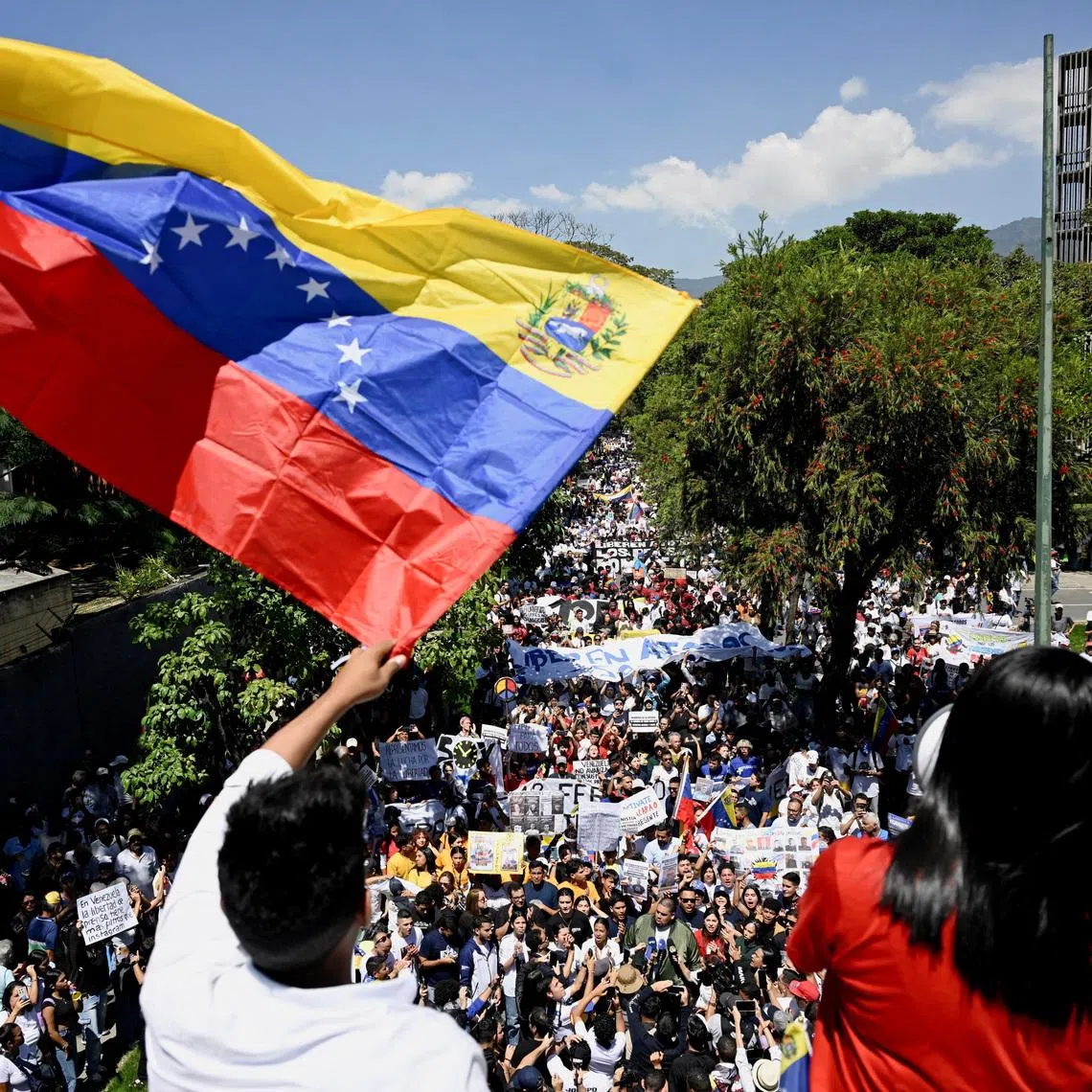 FILE PHOTO: A man waves a Venezuelan flag as university students and relatives of detainees mark Youth Day with a march calling for amnesty for political prisoners, highlighting continued demands for political reforms in the country, in Caracas, Venezuela, February 12, 2026. REUTERS/Maxwell Briceno/ File Photo