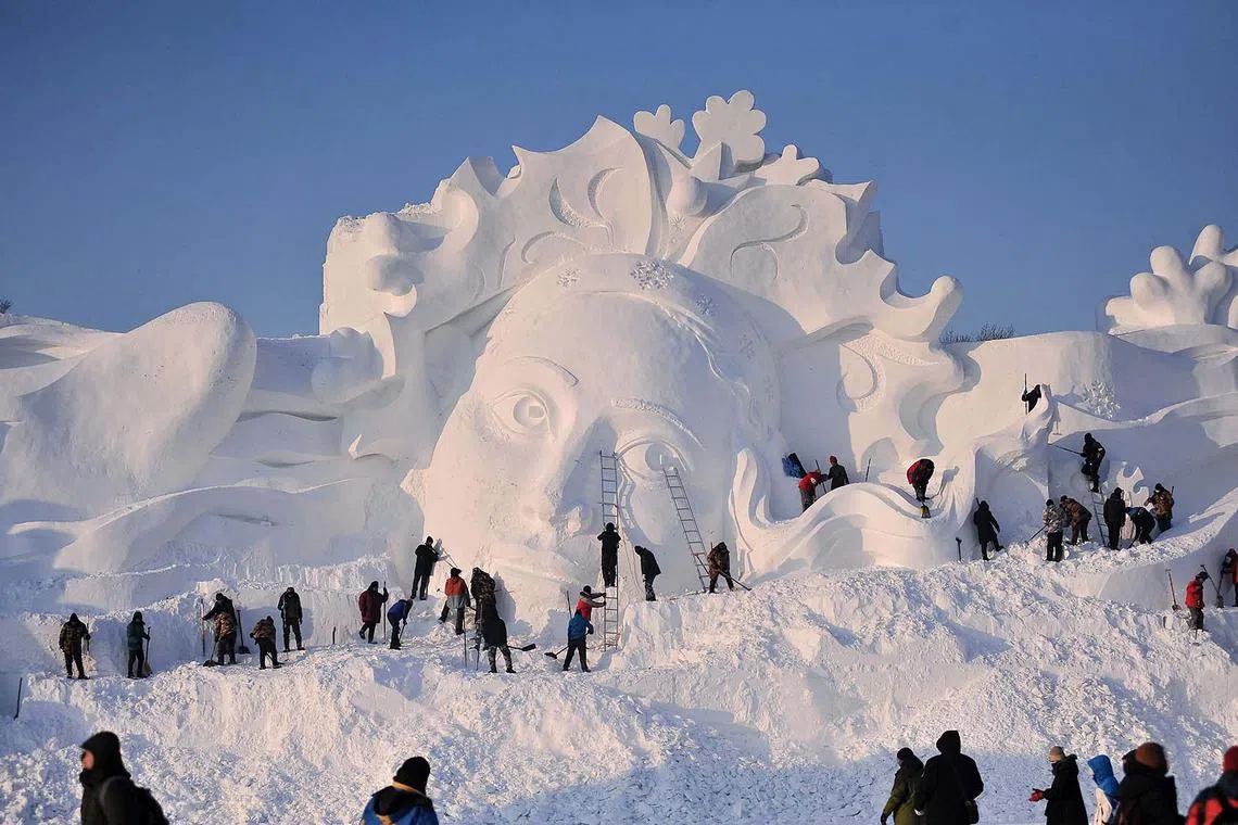 Employees working on a snow sculpture in Harbin in China's northeastern Heilongjiang province on Dec 23, 2023.