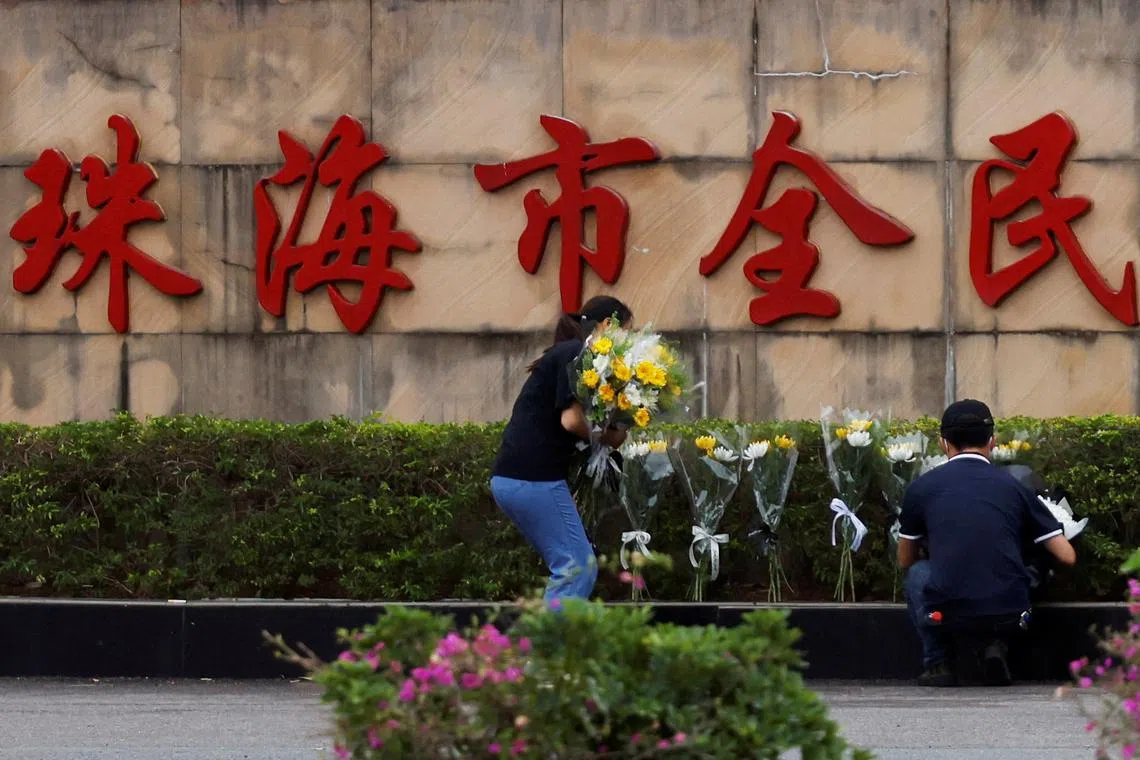 People remove flower bouquets placed outside the sports centre where a deadly car attack took place, in Zhuhai, Guangdong province, China November 13, 2024. REUTERS/Tingshu Wang