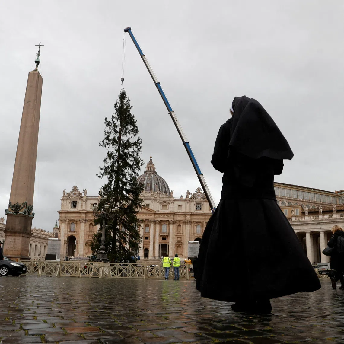 A nun takes a photo of the Christmas tree in St. Peter's Square ahead of the festive season at the Vatican, November 22, 2024. REUTERS/Ciro De Luca
