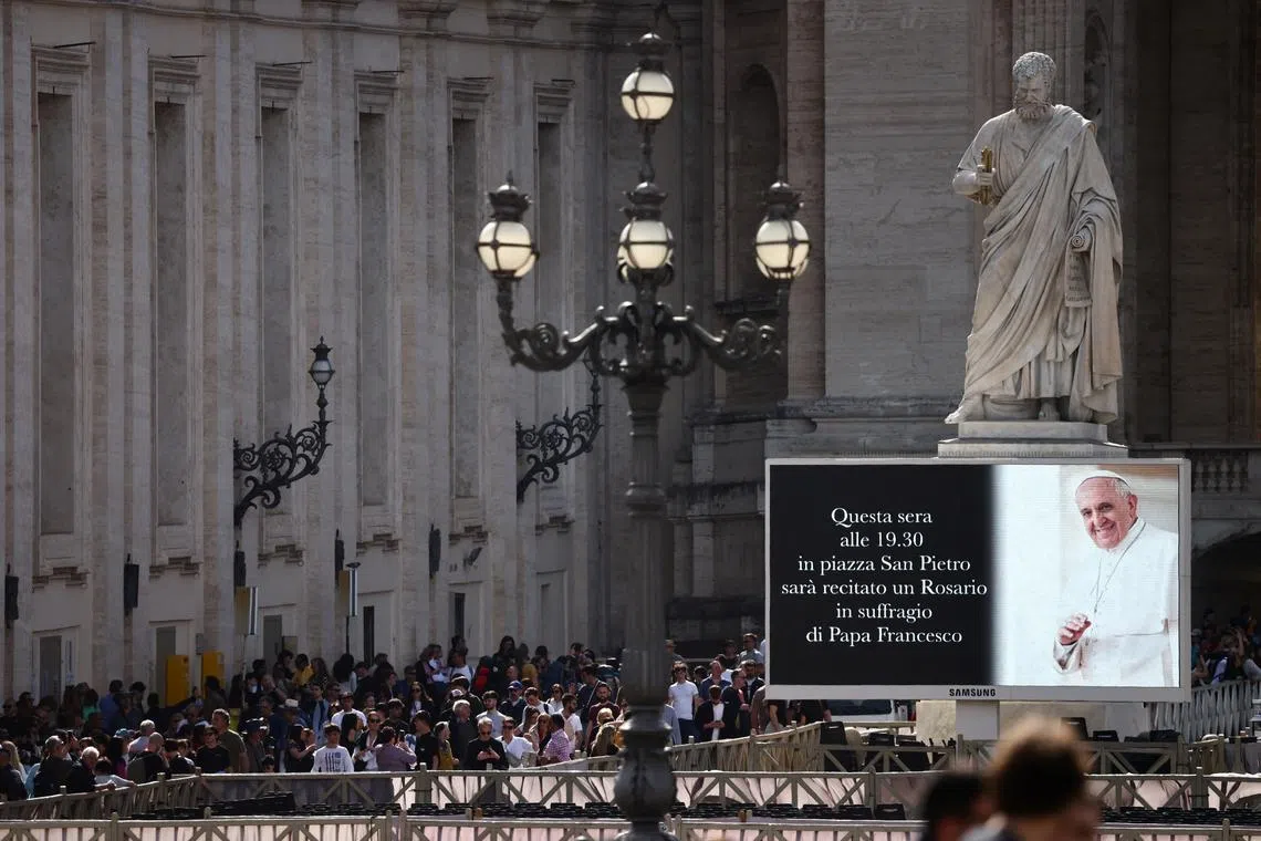 A screen in St. Peter's Square displays an announcement of rosary for Pope Francis, after the death of pontiff was announced by the Vatican, as seen from Rome, Italy April 21, 2025. REUTERS/Yara Nardi
