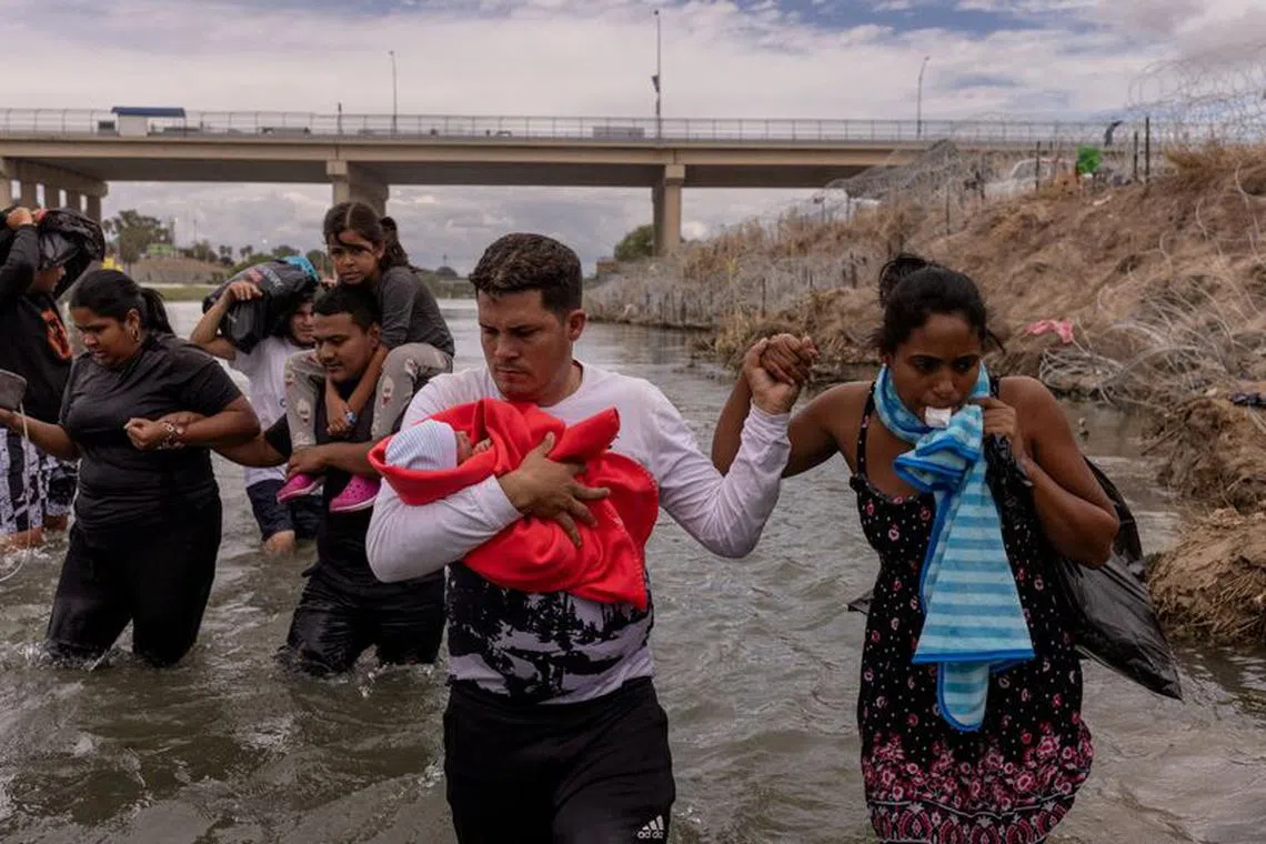 FILE PHOTO: Yusniel, a migrant from Cuba, holds his 10-day-old son, Yireht, and wife, Yanara, as they search for an entry point past a wire fence along the bank of the Rio Grande river after wading into the United States from Mexico in Eagle Pass, Texas, U.S. October 6, 2023.  REUTERS/Adrees Latif/File Photo