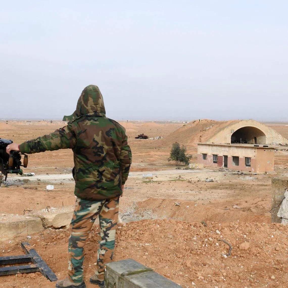 (FILES) A member of Syrian government forces, stands guard the Abu Duhur military air base area in Idlib province, on January 21, 2018. Syria's foreign ministry condemned what it said was an unjustified Israeli attack on an air base in the country's northwest on August 18, 2026, while Israel has not commented on the incident. (Photo by George OURFALIAN / AFP)